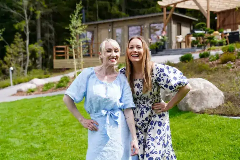 Naiset hirsimökin edustalla