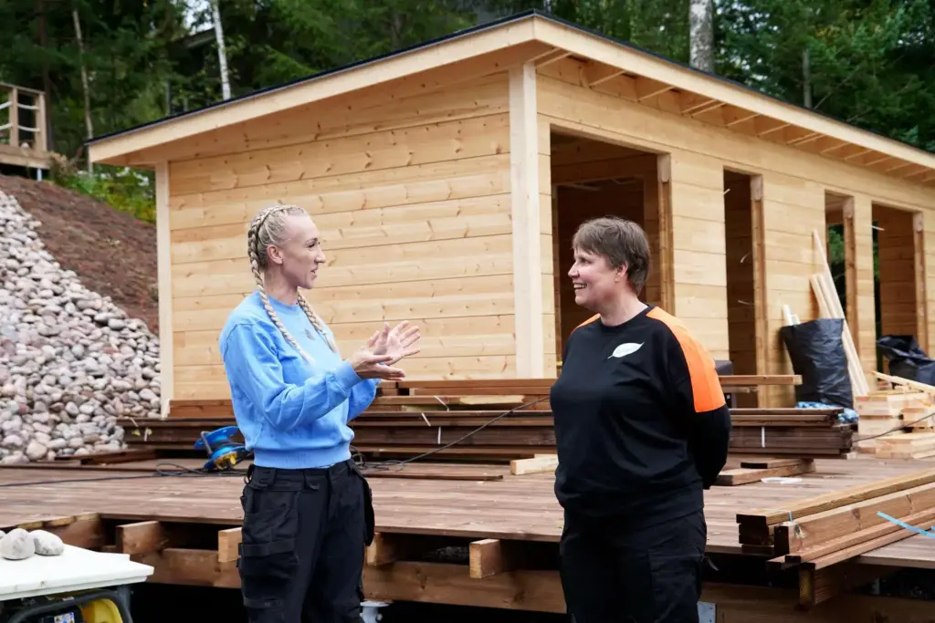 Suunnittelijat rantasaunan edustalla keskustelemassa