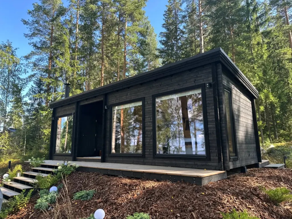 Tumma saunamökki rinnetontilla